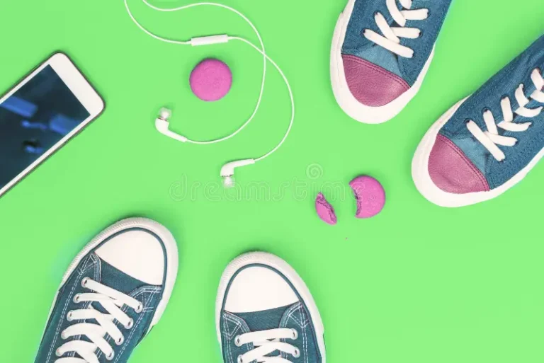 dos-pares-de-zapatillas-deporte-con-el-teléfono-y-los-macarons-la-venta-auriculares-del-celular-rosados-en-fondo-verde-moda-150127308