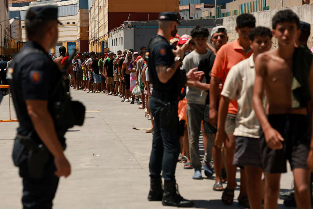 migrantes-hacen-cola-para-recibir-alimentos-basicos-de-la-ong-local-media-luna-blanca-en-una-zona-in (1)